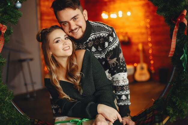 Cute family sitting near Christmas tree