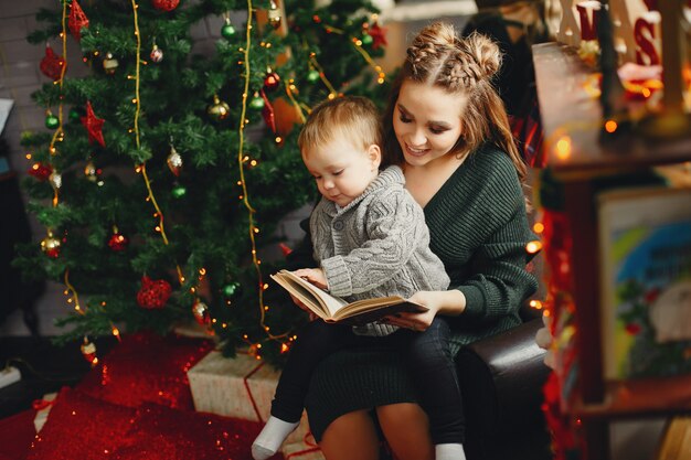 Cute family sitting near Christmas tree