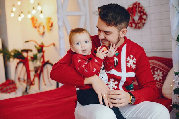 Cute family sitting near Christmas tree