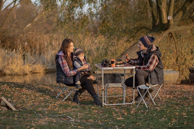 森でピクニックに座っているかわいい家族