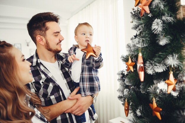 Cute family standing near Christmas tree