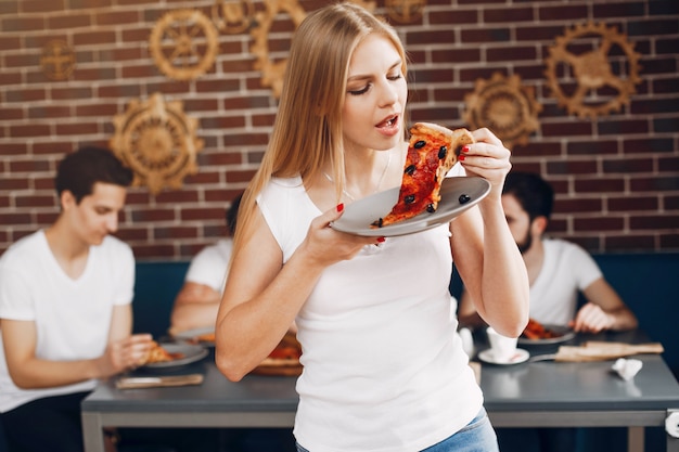 Foto gratuita amici carini in un caffè eatting una pizza