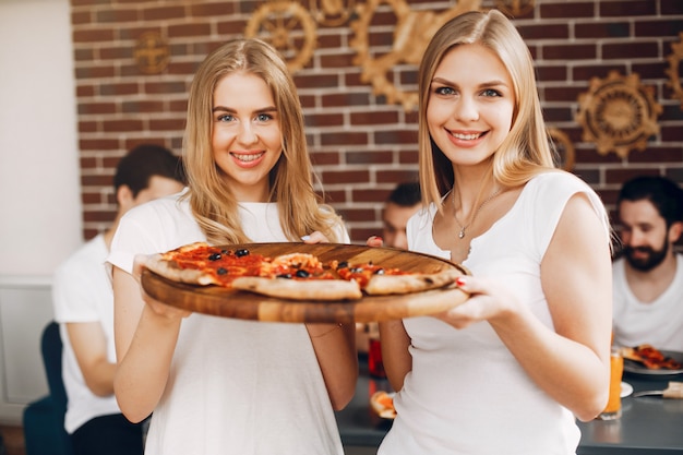 Cute friends in a cafe eatting a pizza