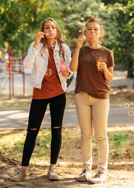 Cute friends making soap bubbles