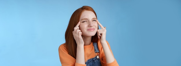 Free photo cute funny european redhead girl forgot glasses trying read sigh stretch eyelids squinting frowning