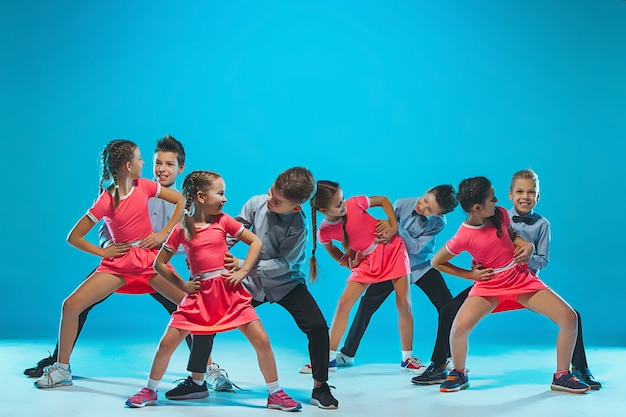 Foto gratuita ragazze e ragazzi divertenti svegli che ballano sul blu