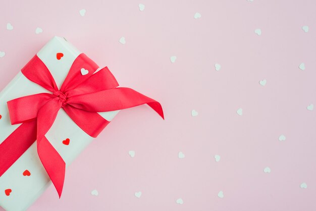 Cute gift near hearts on pink