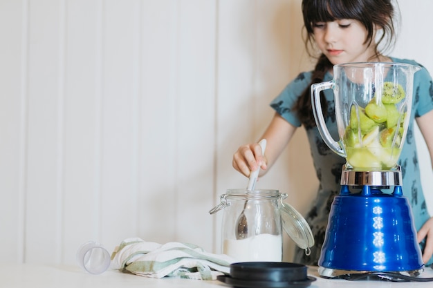 無料写真 かわいい女の子は、ブレンダーに砂糖