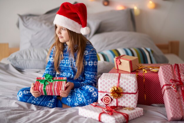 Cute girl in the bed with Christmas presents