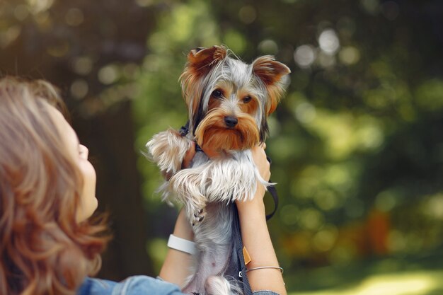 Cute girl in blue jacket playing with little dog