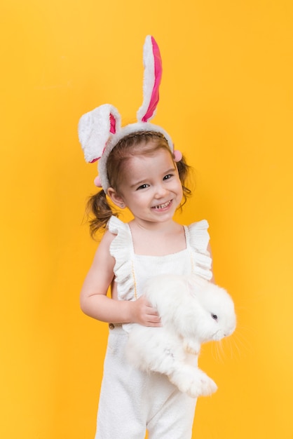 Cute girl in bunny ears with rabbit 