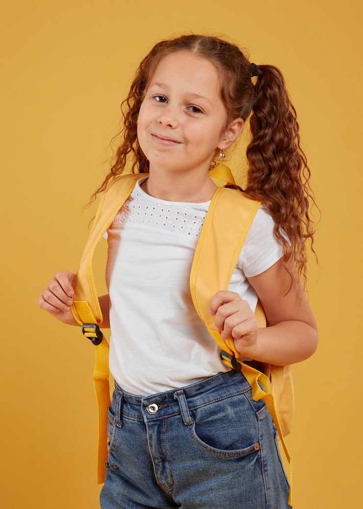 Free Photo cute girl carrying yellow backpack