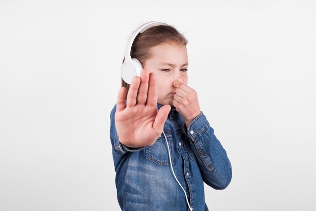 Cute girl covering nose and showing stop gesture