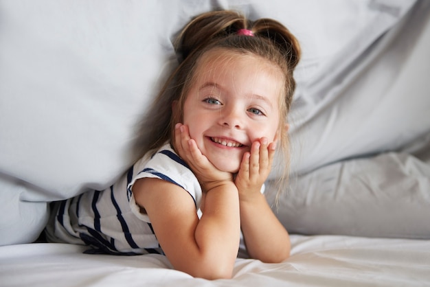 Free photo cute girl under the duvet