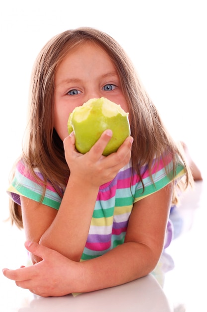 Милая девушка ест яблоко