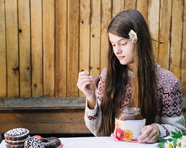 Foto gratuita la ragazza sveglia che mangia il cioccolato si è diffusa con il cucchiaio su natale