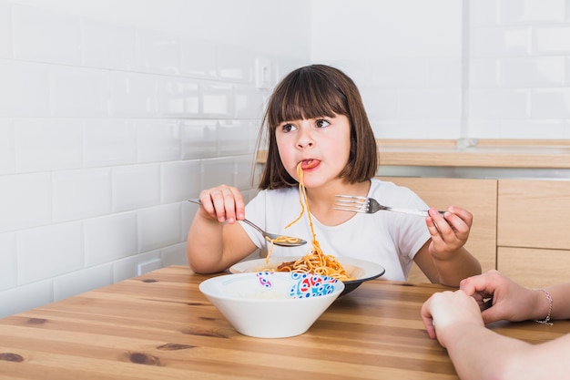 Free photo cute girl eating pasta