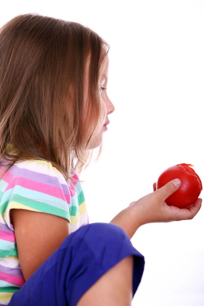 Cute girl eating a tomato