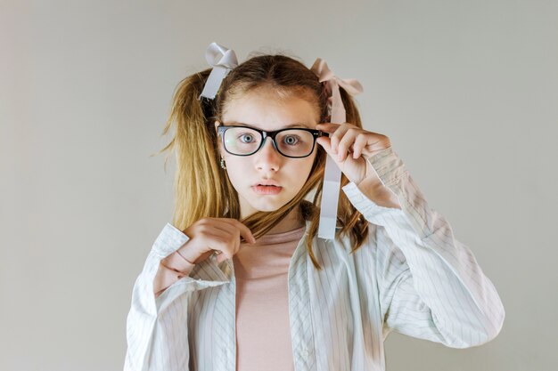 Cute girl in eyeglasses holding her hair