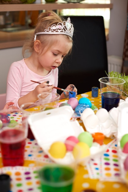 Cute girl focused on her handmade easter eggs