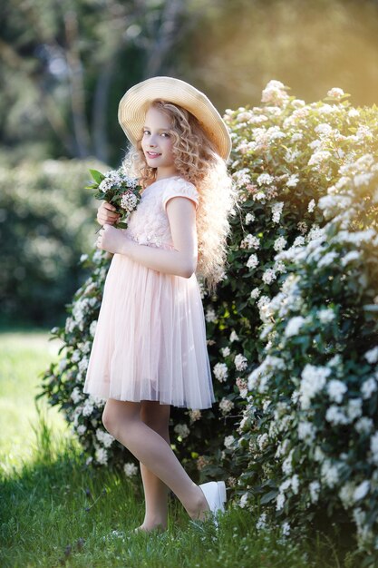 cute girl in hat with flowers outdoor