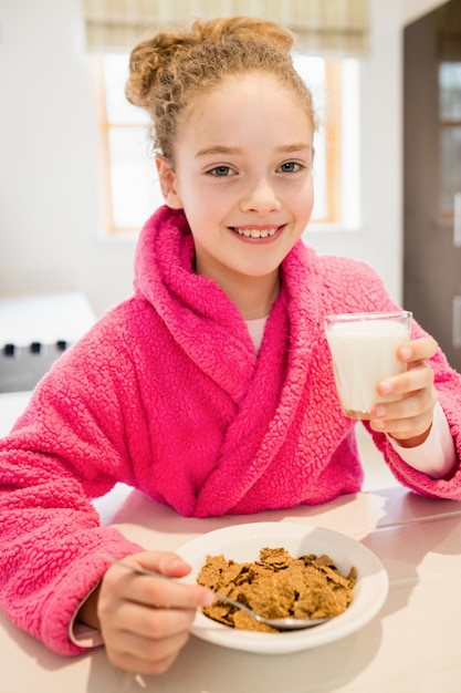 Free photo cute girl having breakfast in kitchen