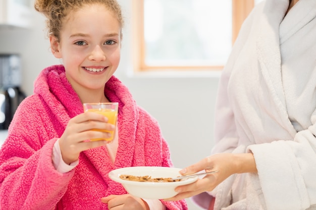 Cute girl having breakfast in kitchen