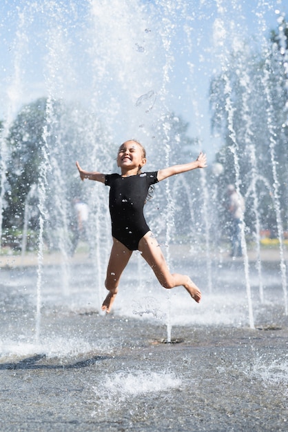 Cute girl having fun at fountain