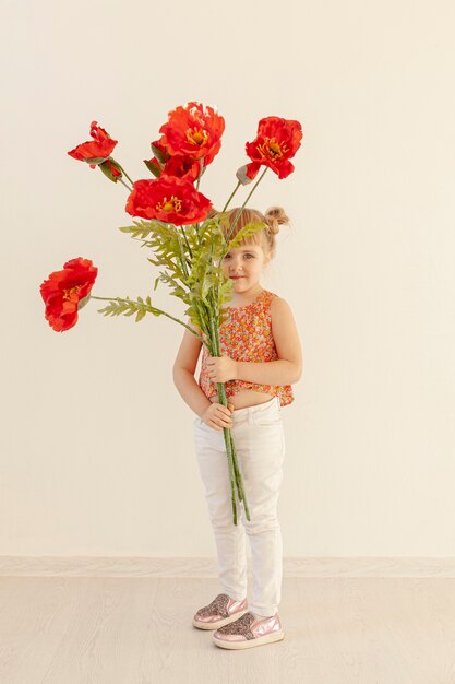 큰 빨간 꽃을 들고 귀여운 여자