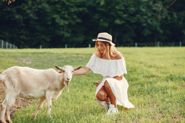 Бесплатное фото Милая девушка в поле с козами