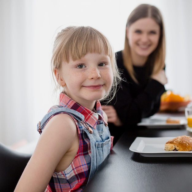 Cute girl looking at camera during breakfast