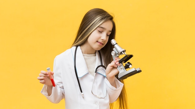 Free photo cute girl looking through microscope