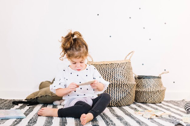 Cute girl looking at toy near baskets