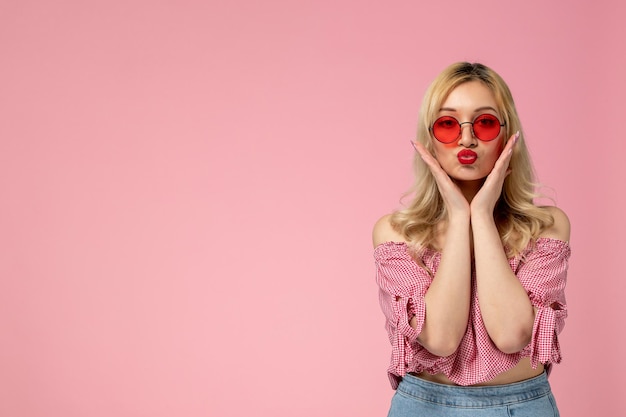 Free photo cute girl lovely young lady with red glasses in pink blouse sending kisses and holding face