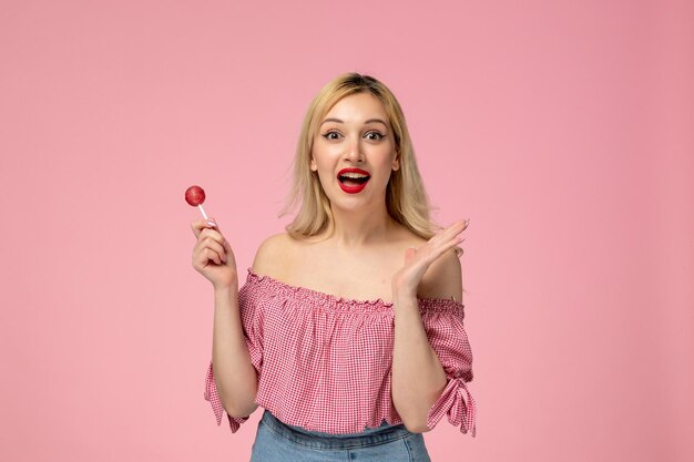 Милая девушка, милая юная леди с красной помадой в розовой блузке, так рада ягодному леденцу на палочке
