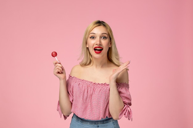 Cute girl lovely young lady with red lipstick in pink blouse so happy for a berry lollipop