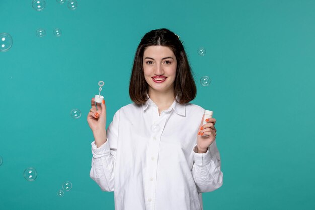 Cute girl lovely young pretty brunette girl in white shirt with soap bubbles in air