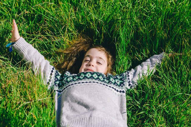 Симпатичная девушка, лежа на траве