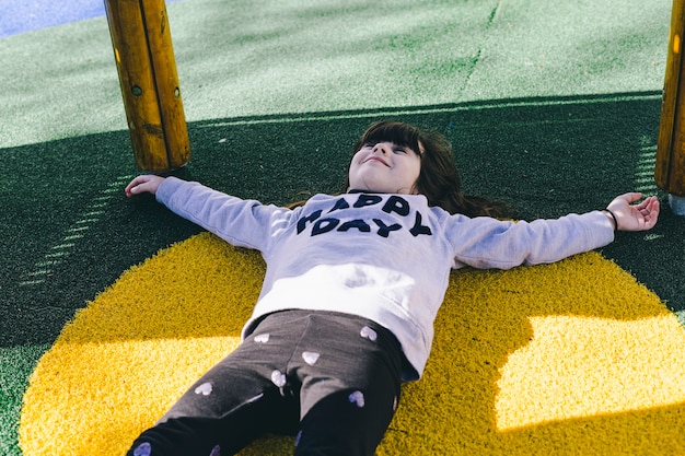 Free photo cute girl lying under playground