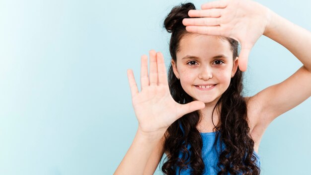 Cute girl making camera shape with hands