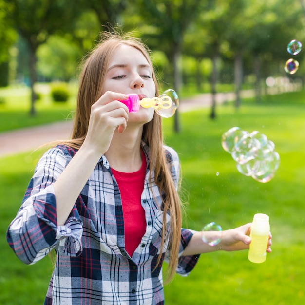 Free photo cute girl making soap bubbles