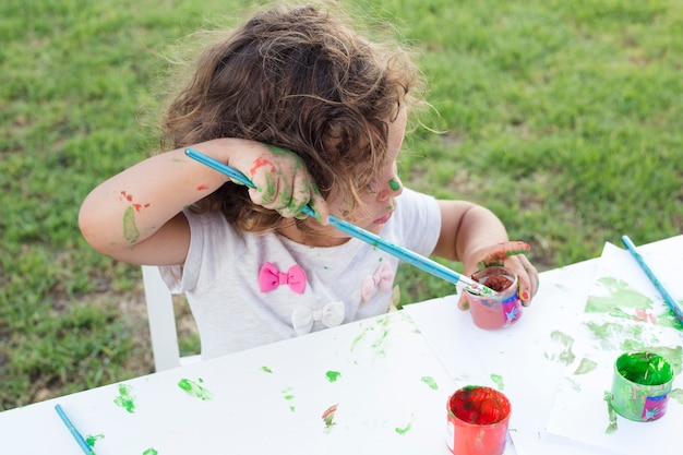 かわいい女の子、公園でブラシで絵