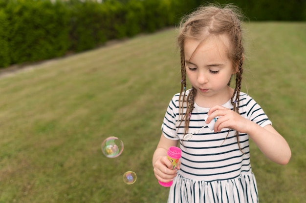 Милая девушка играет с воздуходувка пузыря