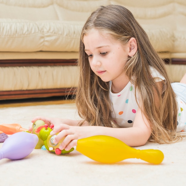 Бесплатное фото Симпатичная девушка, играющая с игрушками у себя дома