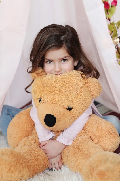 Cute girl posing with big teddy bear