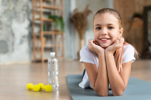 Cute girl posing on yoga mat