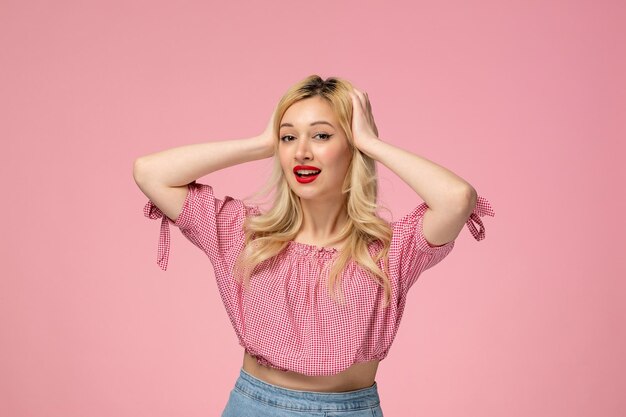 Cute girl pretty blonde lady wearing red lipstick in pink blouse holding head and posing