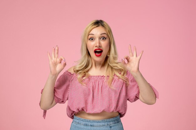 Cute girl pretty blonde lady wearing red lipstick pink blouse showing ok gesture and surprised