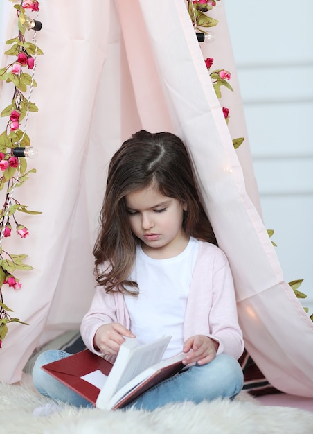 Cute girl reading a book around cute decoration