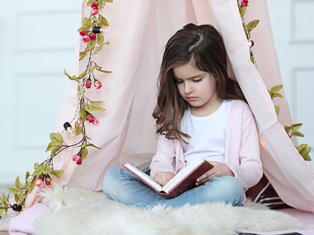 Cute girl reading a book around cute decoration
